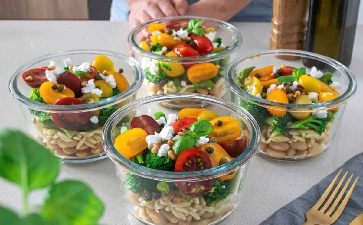 A vegan bean, orzo, pesto salad, all divided into separate containers for meal-prepping part of high protein vegan jarred salads
