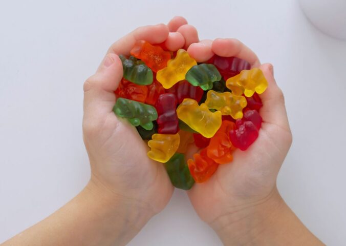 Photo shows a child's hands as he cups jelly beans in the shape of a heart