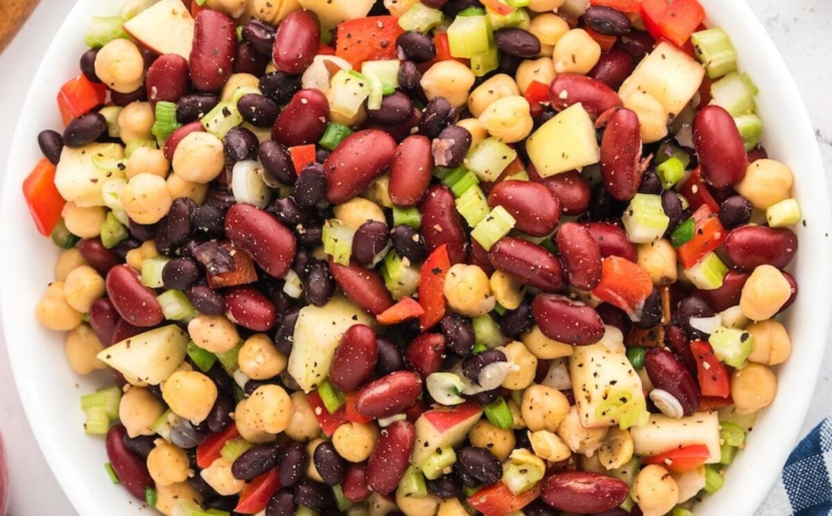 three bean salad made with chickpeas, kidney beans, black beans, apple pieces, and a tangy vinegar dressing