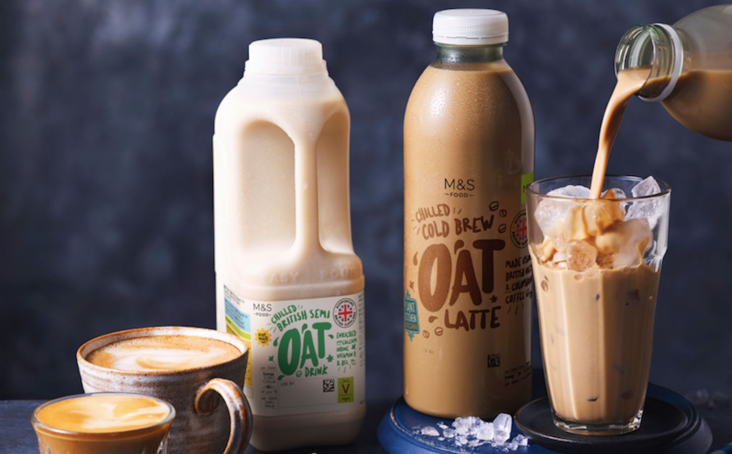 A vegan oat milk carton beside some milky dairy-free drinks
