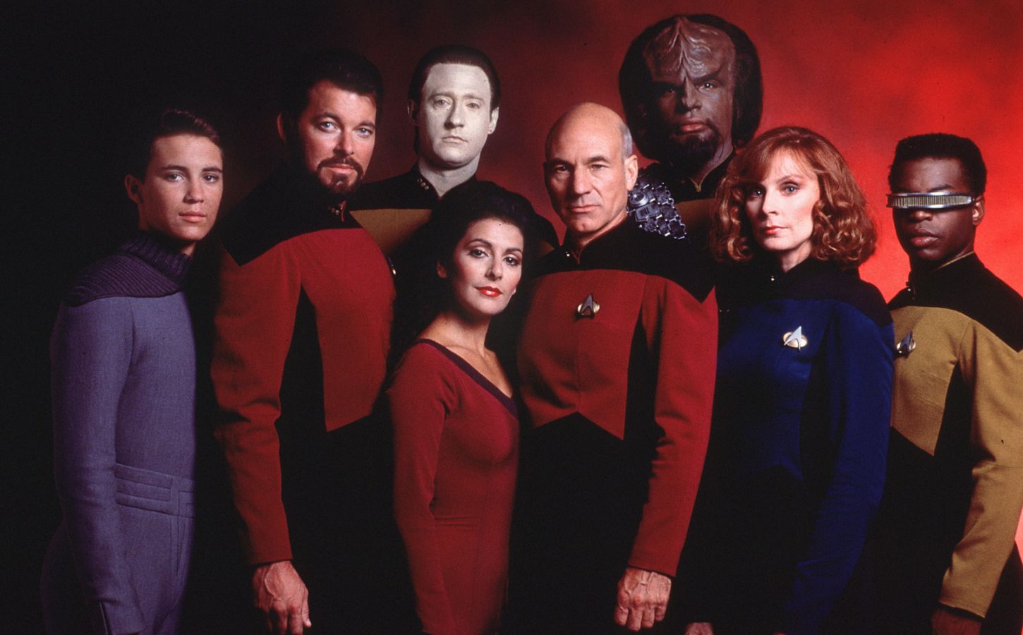 The cast of Star Trek Next Generation, said to contain vegan messaging, stood in front of a red background