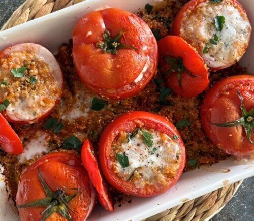 A tray of quinoa stuffed tomatoes with plant-based feta