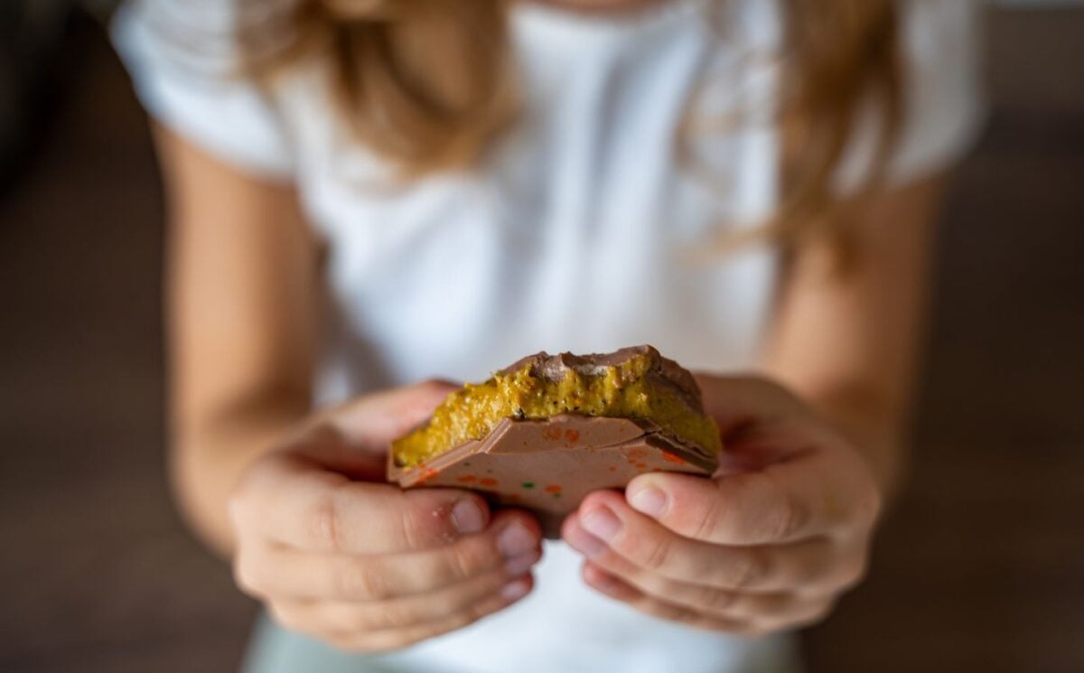 Photo shows someone holding a pistachio-filled "Dubai Chocolate" bar